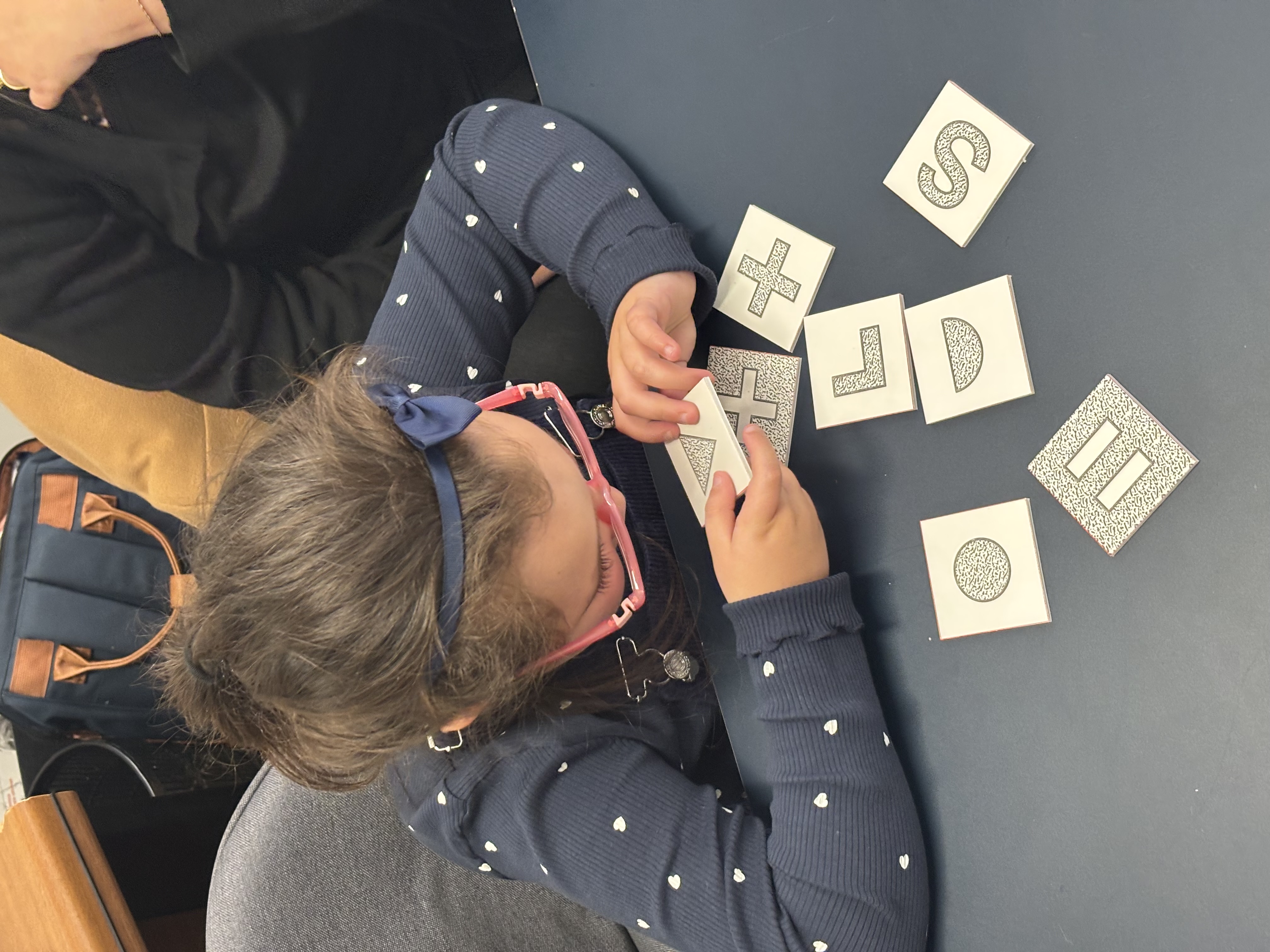 Petite fille qui fait un mémory tactile